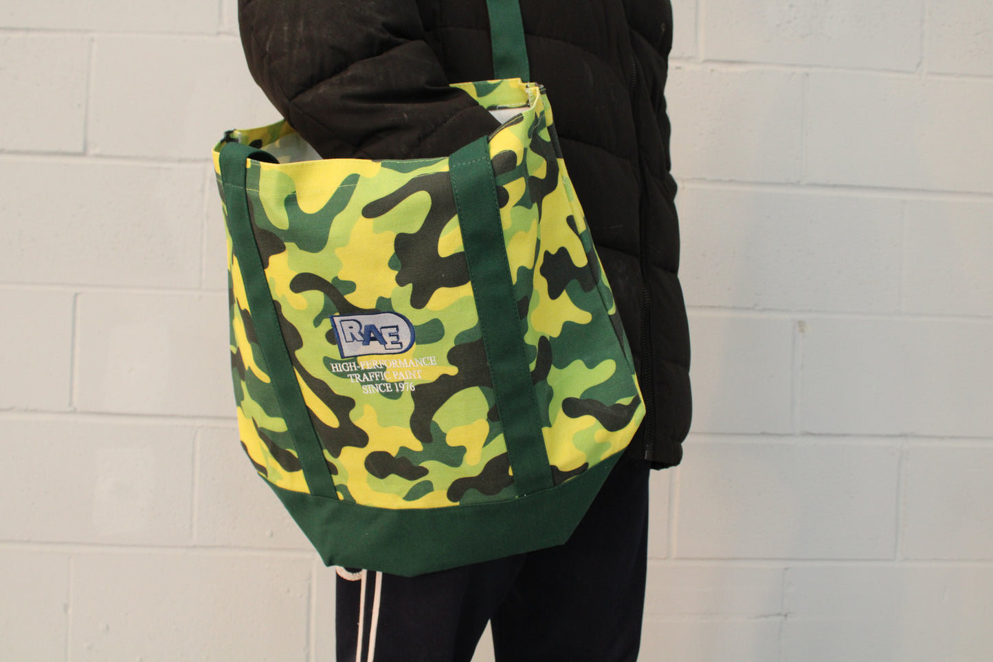 a picture of a person using the RAE green camo nature tote bag