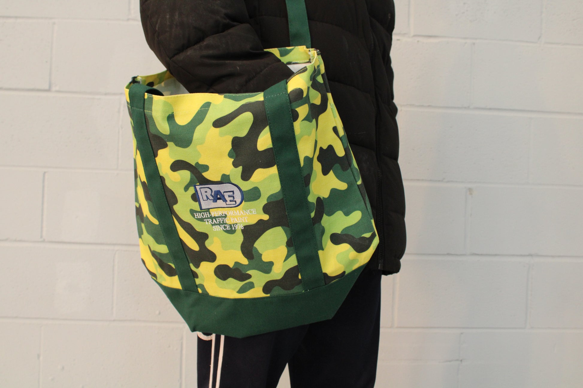 a picture of a person using the RAE green camo nature tote bag