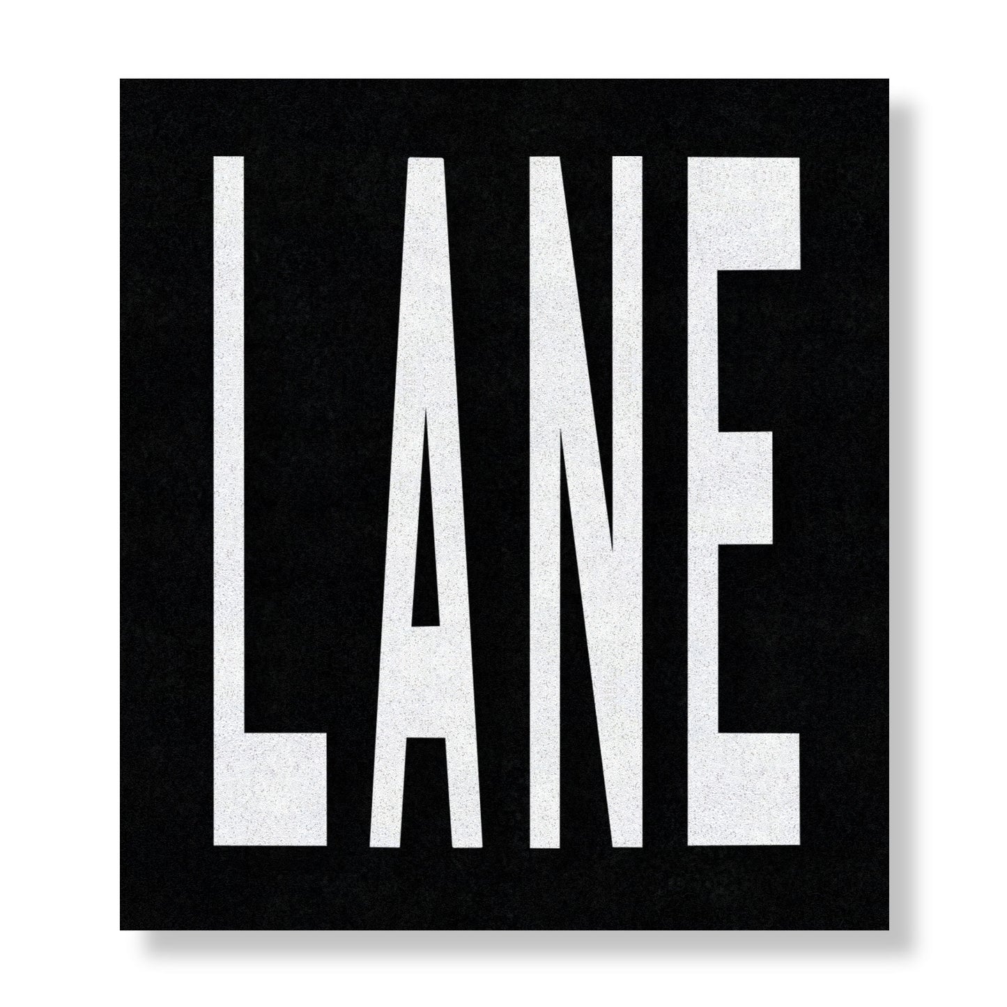 White preformed thermoplastic text LANE in all capital letters on a black rectangle.