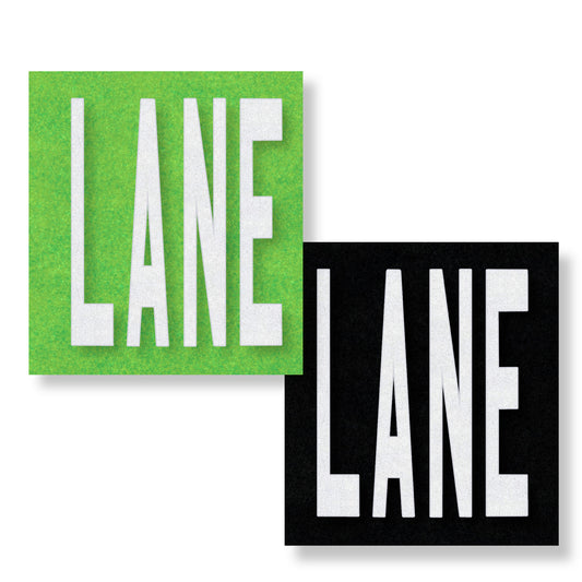 White preformed thermoplastic text LANE in all capital letters on green and black rectangles.