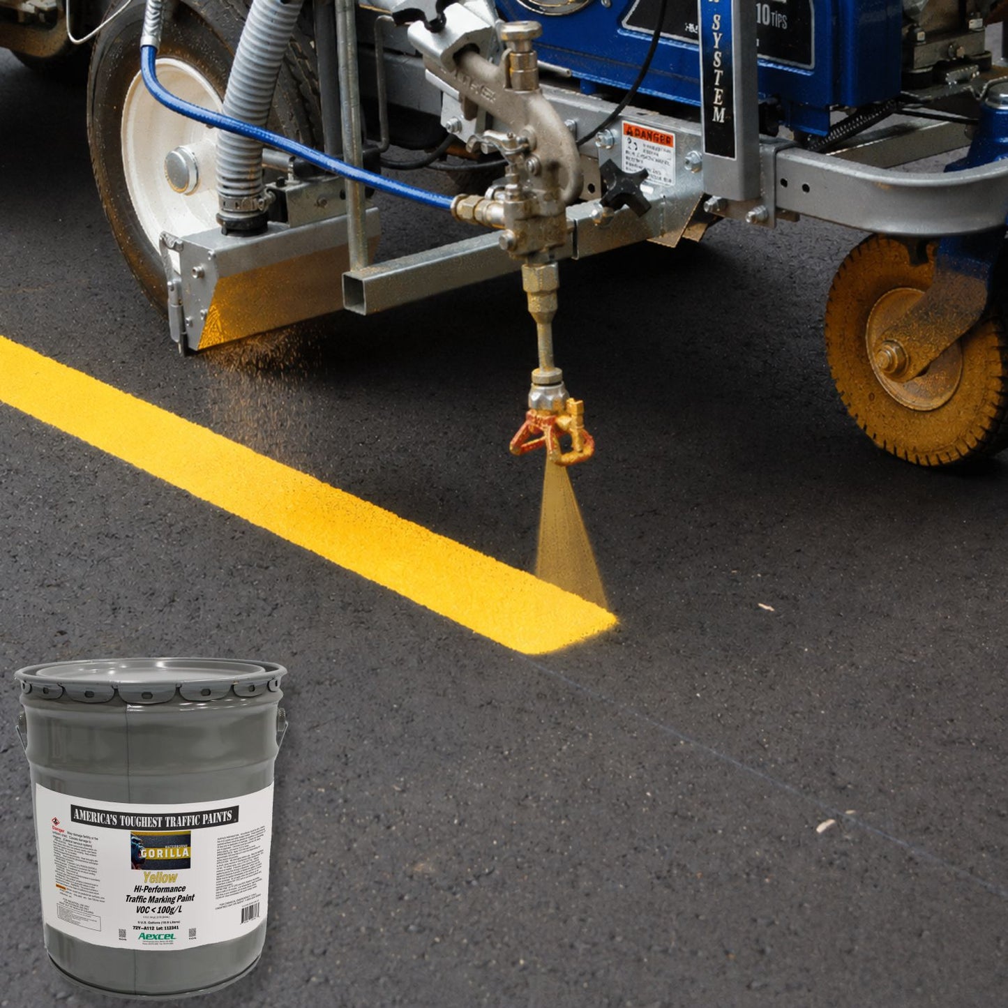 Road striping machine applying a bright yellow Gorilla traffic marking paint line on fresh asphalt pavement.