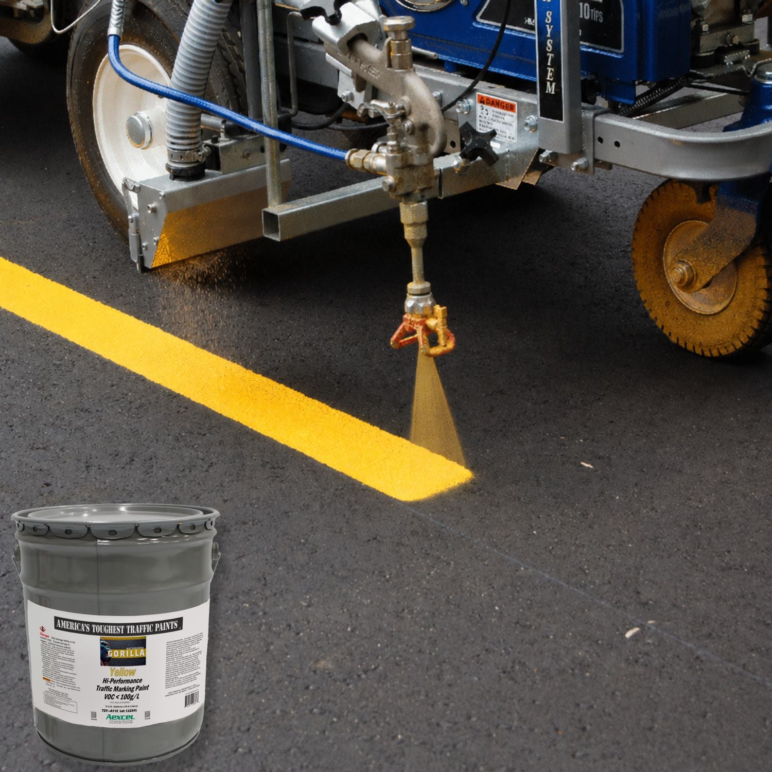 Road striping machine applying a bright yellow Gorilla traffic marking paint line on fresh asphalt pavement.