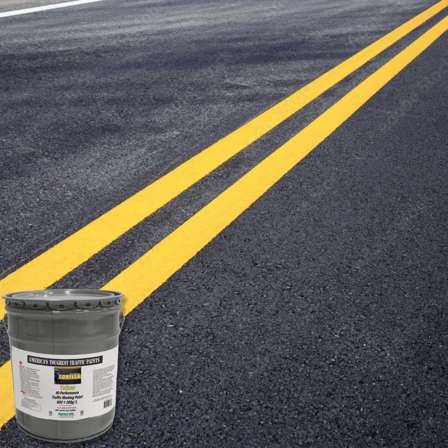 Freshly painted double yellow centerlines on asphalt roadway using Aexcel Gorilla yellow traffic marking paint.
