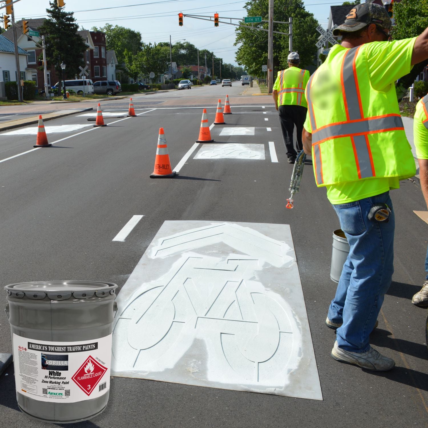 Road crew applying a white bicycle lane stencil on newly paved asphalt using Aexcel Gorilla Traffic Marking Paint for durable, high-visibility bike lane markings.
