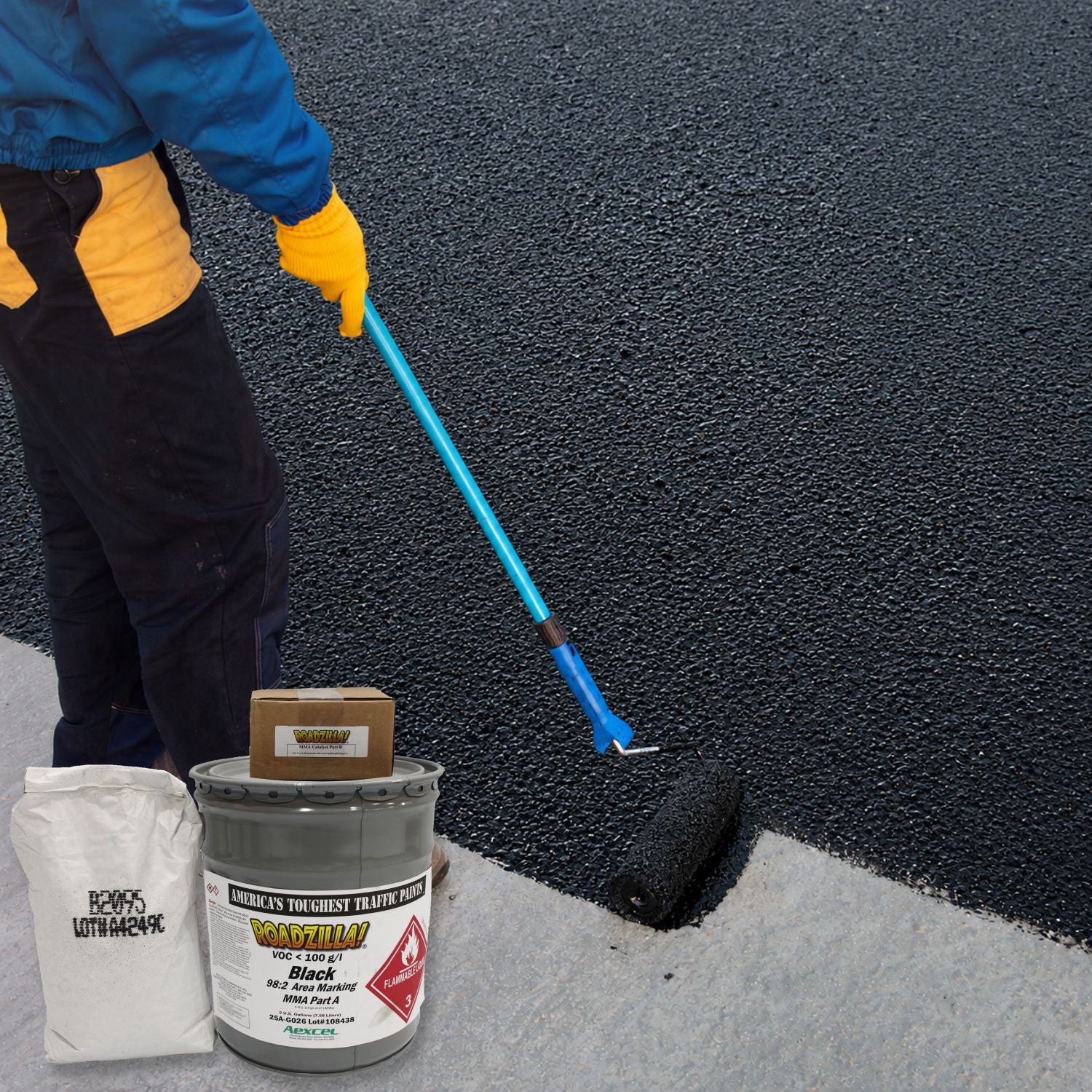 RoadZilla Black MMA high-friction area marking system being roller-applied to create a durable anti-skid pavement surface on asphalt.