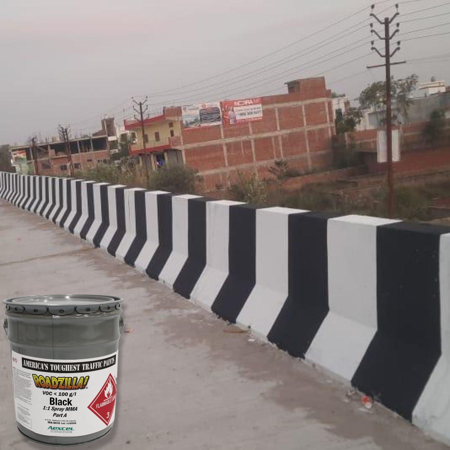 RoadZilla Black MMA traffic marking paint used for high-visibility black and white concrete barrier striping on a bridge or roadway.