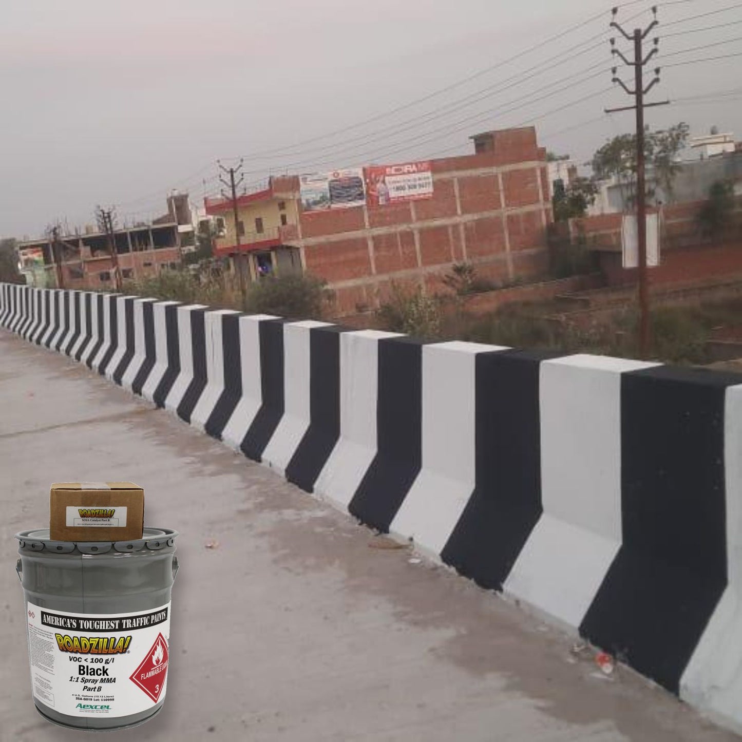 RoadZilla Black MMA traffic marking paint used for high-contrast black and white concrete barrier striping on a roadway.