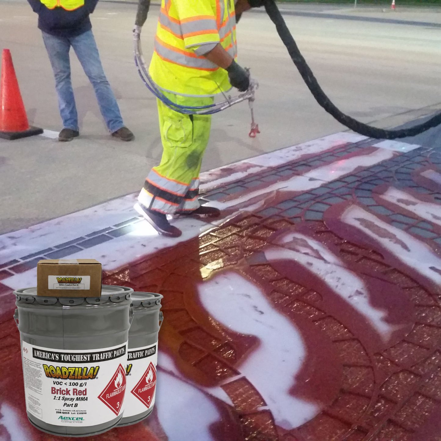 RoadZilla Brick Red MMA Traffic Marking Paint being applied to a decorative crosswalk using a plural-component spray system, creating durable textured pavement markings for pedestrian safety and streetscape enhancement.