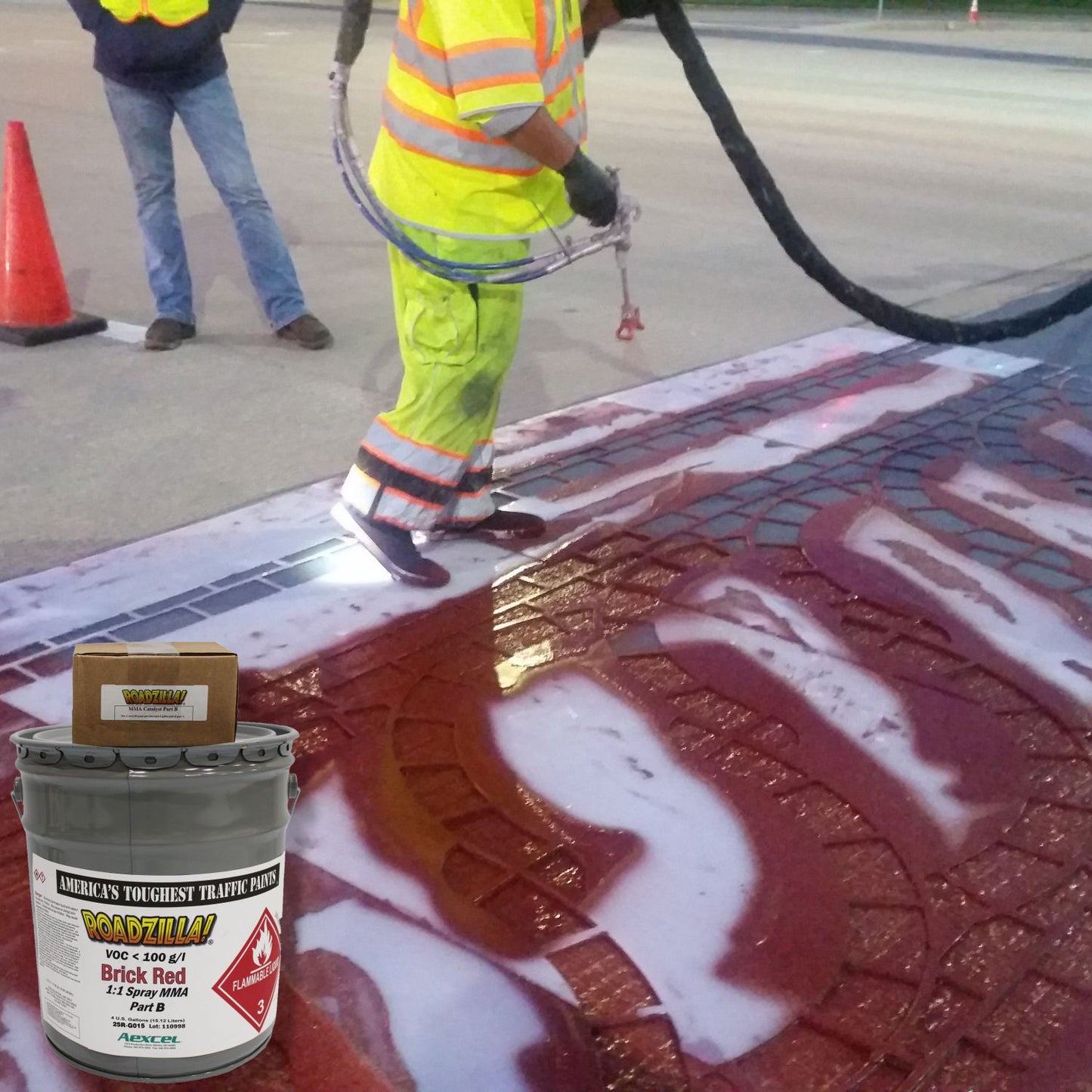 RoadZilla Brick Red MMA traffic marking paint being applied to a decorative brick-pattern crosswalk using a plural-component spray system.
