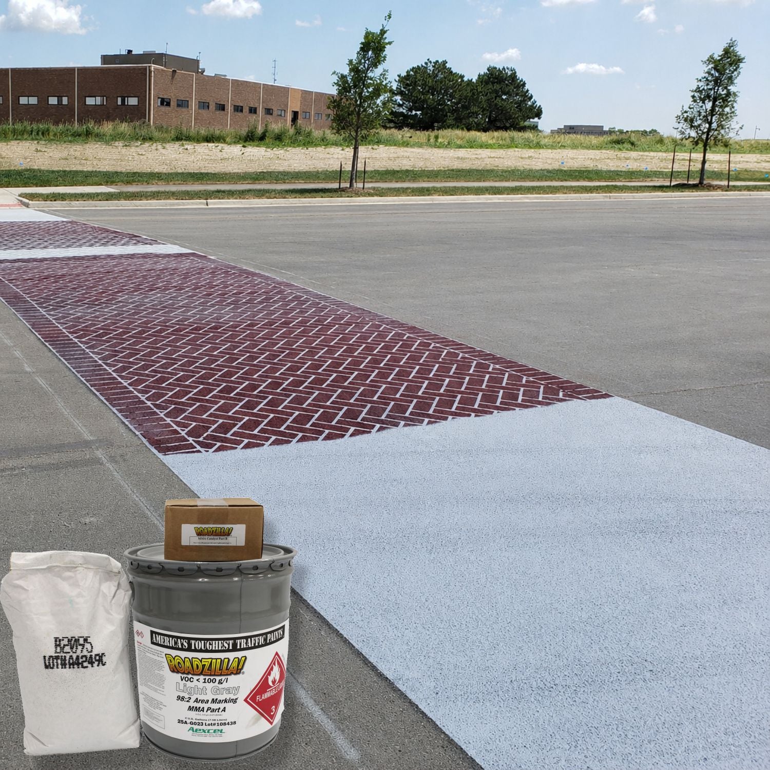 RoadZilla Light Gray MMA High Friction Surfacing System installed as a decorative brick-pattern crosswalk treatment on a roadway.