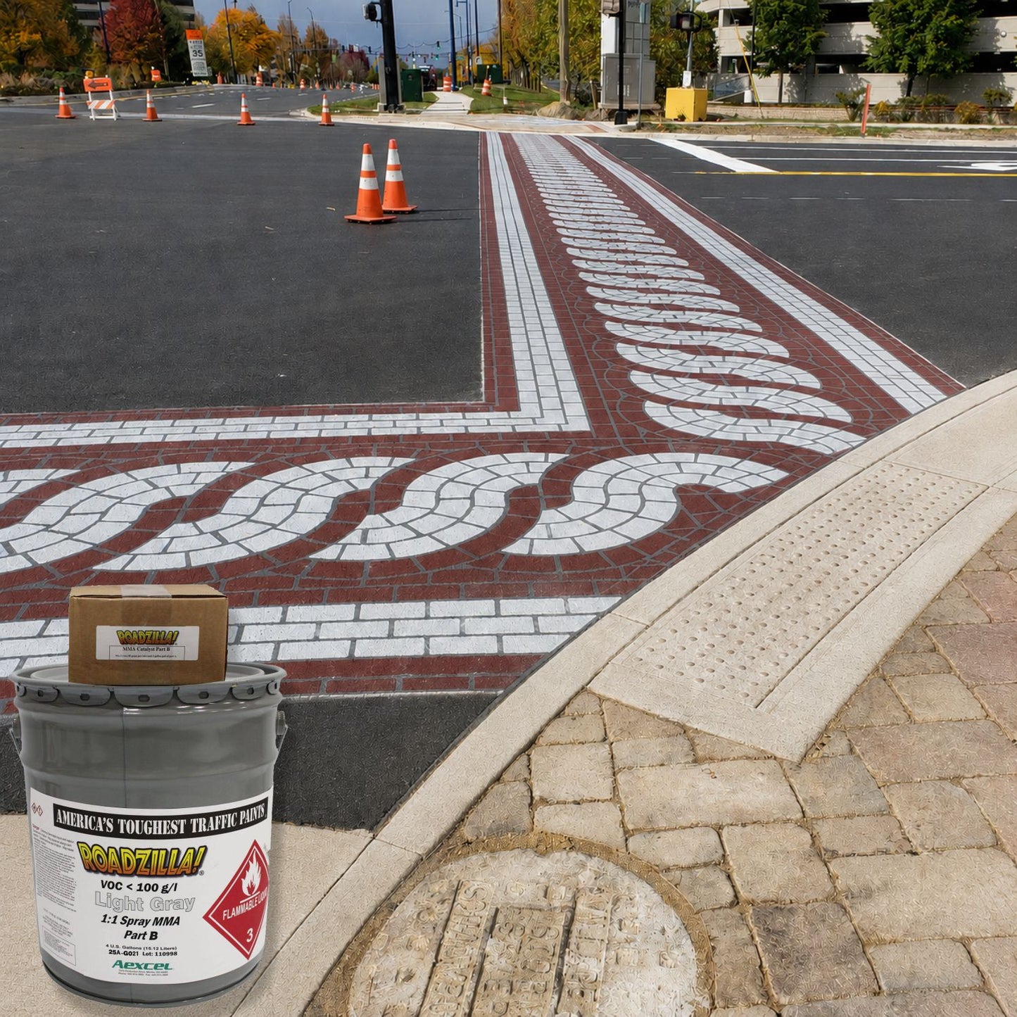 RoadZilla Light Gray MMA traffic marking paint used to create a decorative brick-pattern crosswalk and intersection treatment on an urban roadway.