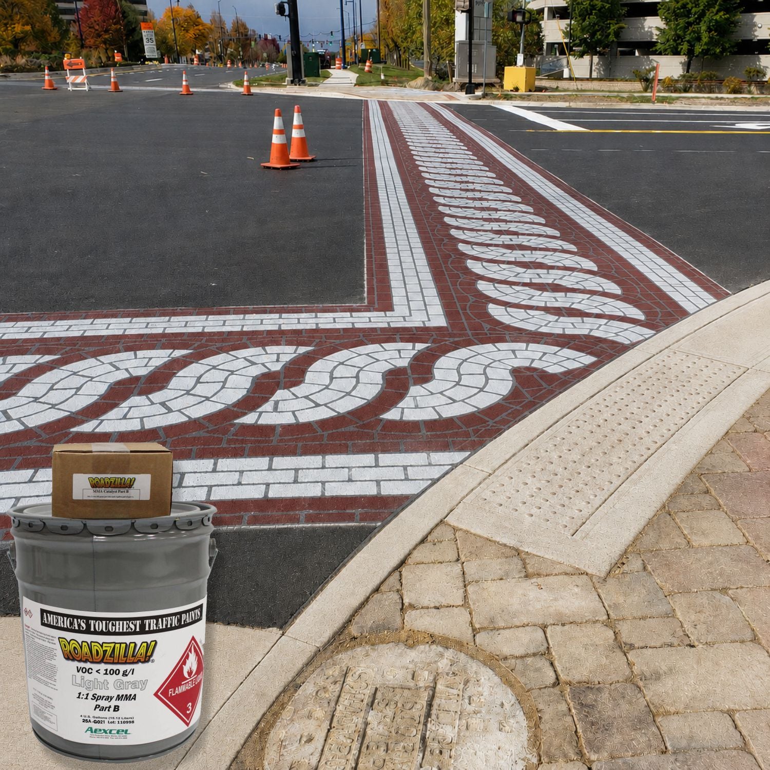 RoadZilla Light Gray MMA traffic marking paint used to create a decorative brick-pattern crosswalk and intersection treatment on an urban roadway.