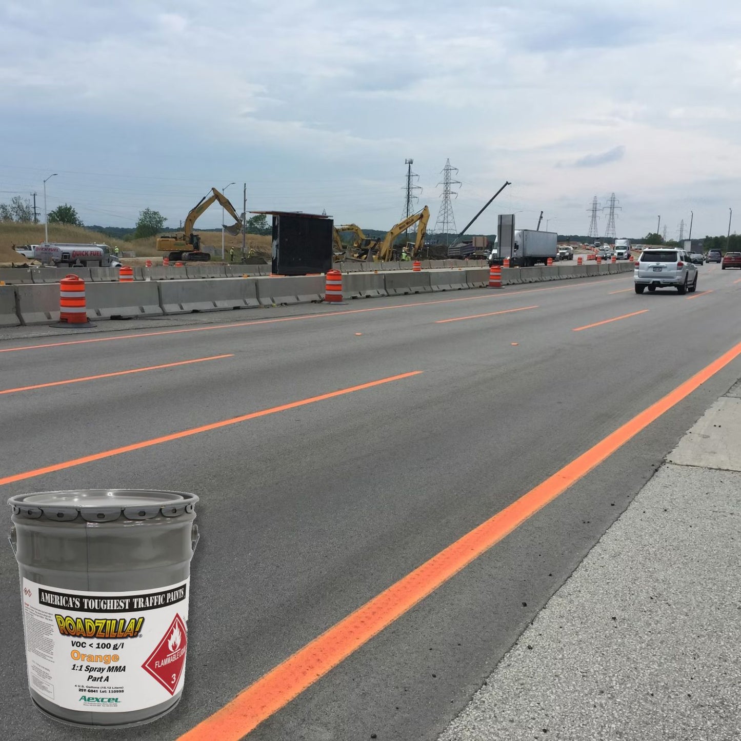 RoadZilla Orange MMA traffic marking paint used to create bright temporary lane markings on a highway construction project with active traffic and work zone barriers.