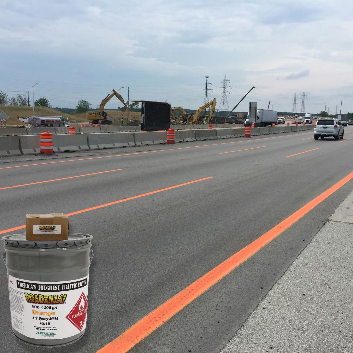 RoadZilla Orange MMA traffic marking paint used for high-visibility temporary lane striping in a highway construction work zone.