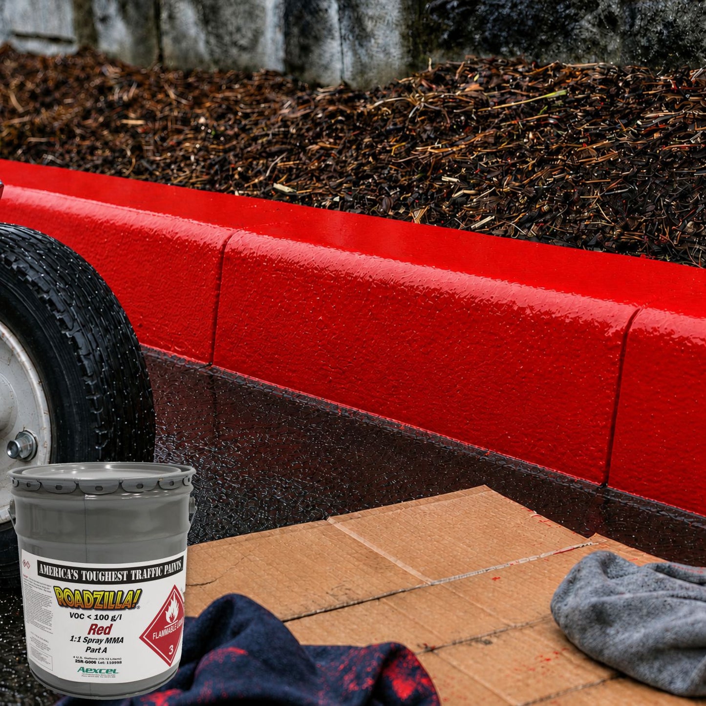 Freshly painted red fire lane curb coated with RoadZilla Red MMA traffic marking paint, showing a smooth, glossy finish and exceptional color coverage along a commercial landscape border.