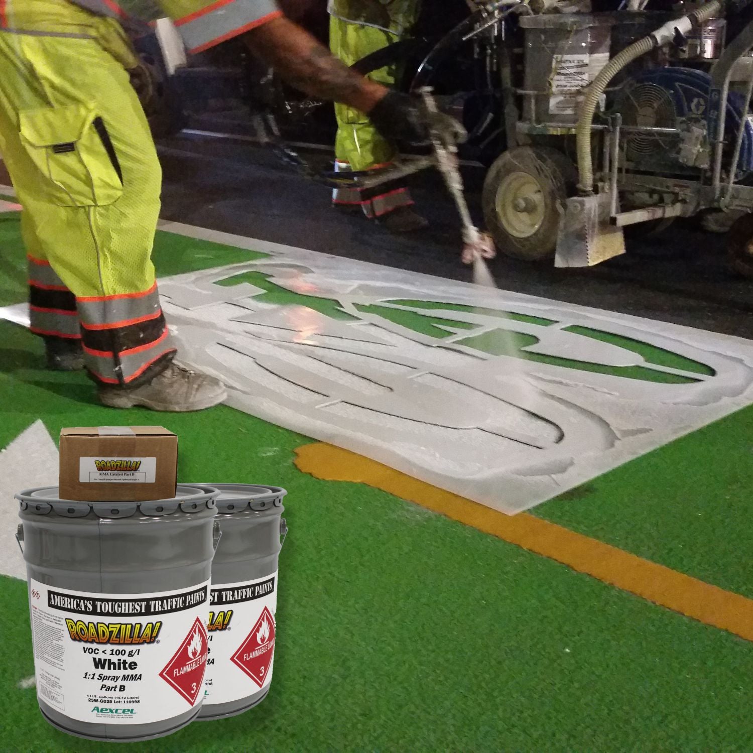 RoadZilla White MMA traffic marking paint being spray-applied through a stencil to create a durable bicycle lane symbol on a green pavement surface using a 1:1 plural-component striping system.