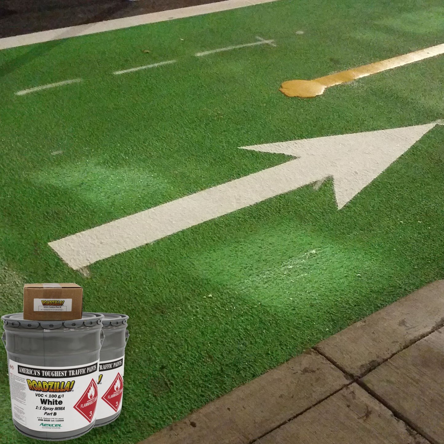 RoadZilla White MMA traffic marking paint used to create a high-visibility directional arrow on a green bike lane surface.