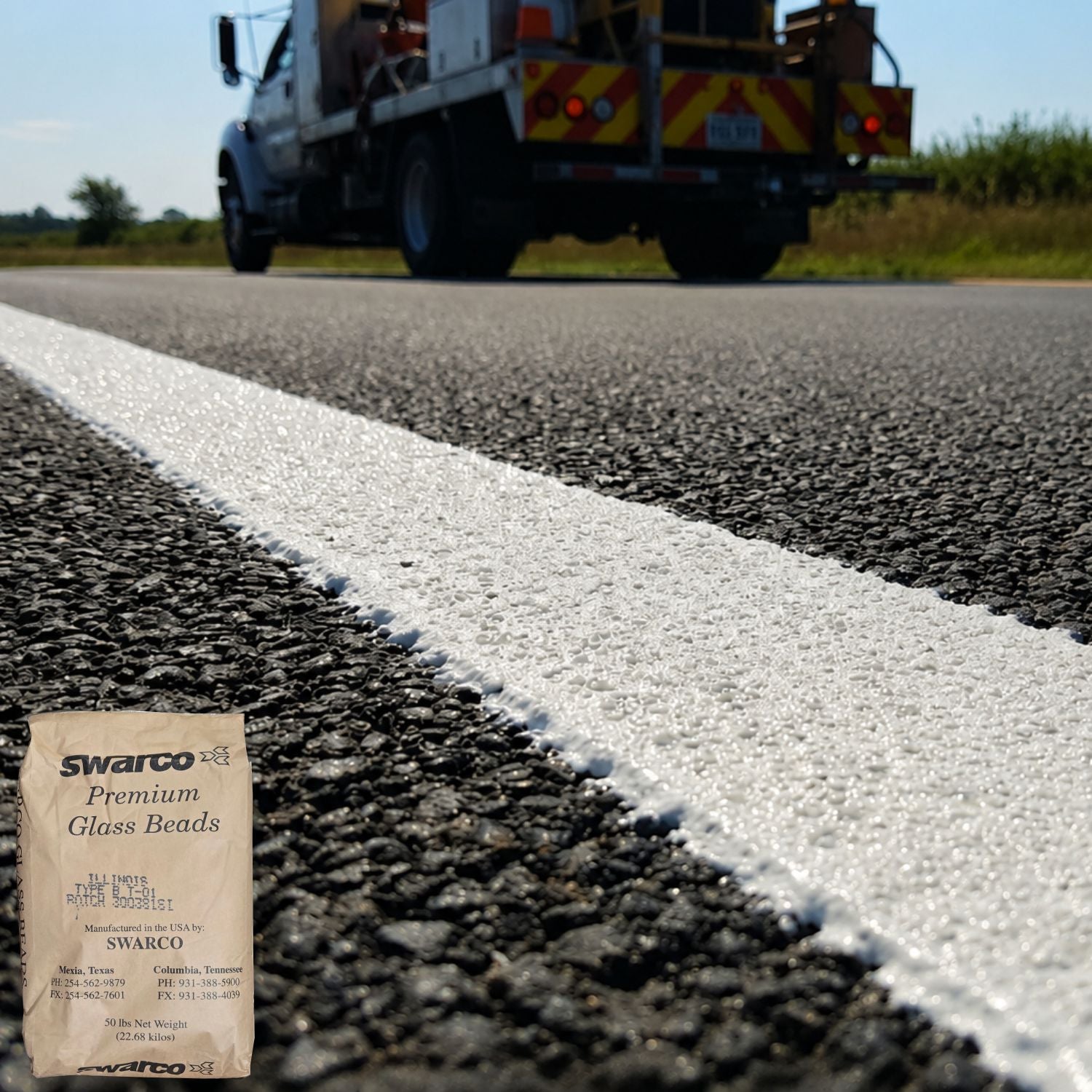 SWARCO Illinois Type-B glass beads embedded in a white pavement marking line on asphalt, providing enhanced retroreflectivity and long-lasting roadway visibility.